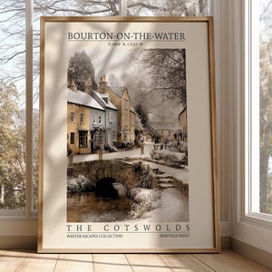 May include: A framed print featuring a sepia-toned image of Bourton-on-the-Water in the Cotswolds. The print shows a stone bridge over a river, with buildings lining the street. The text "BOURTON-ON-THE-WATER" and "THE COTSWOLDS" is visible.