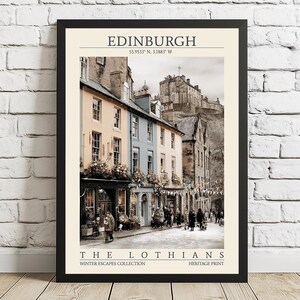 May include: A framed print featuring a street scene in Edinburgh, Scotland, with buildings in shades of yellow, blue, and beige. The image includes the text "EDINBURGH" and "THE LOTHIANS". The print is part of the "Winter Escapes Collection".