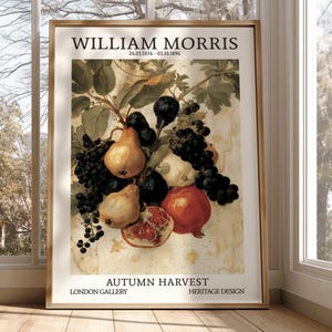 May include: A framed art print titled William Morris Autumn Harvest featuring a still life of pears, dark grapes, and a pomegranate. The text includes the artist's name, dates 24.03.1834 - 03.10.1896, London Gallery, and Heritage Design on a cream background.