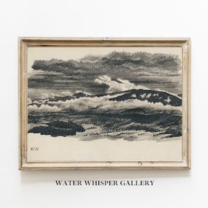 May include: A framed black and white pencil drawing of a mountain range with clouds. The drawing is signed "KW" in the bottom left corner. The frame is a light wood color.
