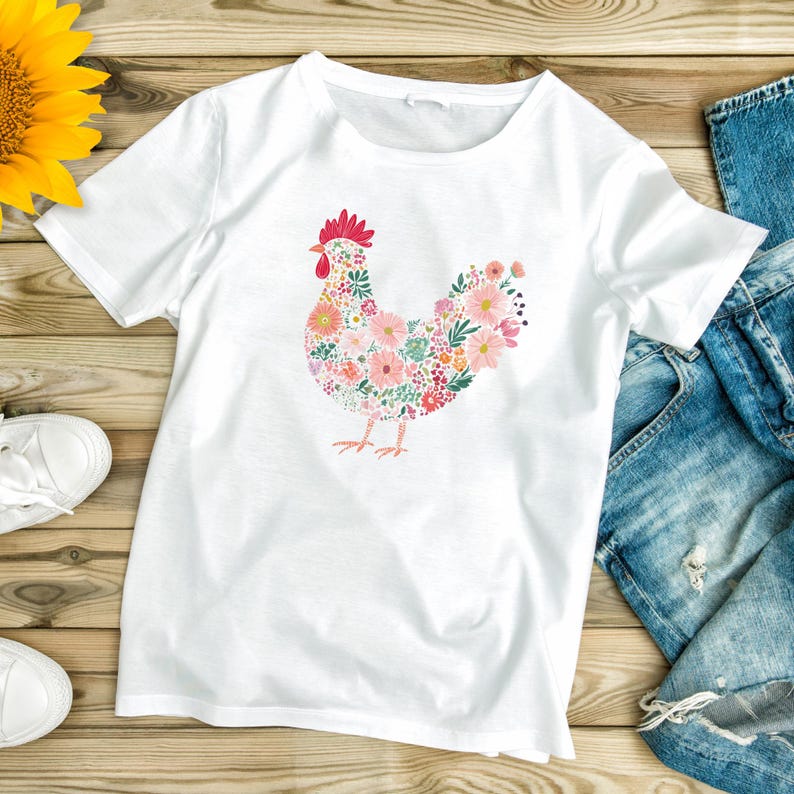 May include: White t-shirt featuring a floral hen design. The hen is composed of pink, peach, and green flowers, with a red comb and beak. The shirt is made of a soft material and is suitable for casual wear.