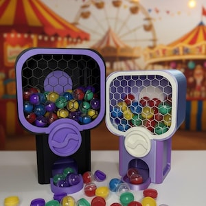 May include: Two colorful gumball machines with a carnival backdrop. The machines are purple and black, filled with multi-colored gumballs. The gumballs are scattered around the base of the machines. The machines have a honeycomb pattern on the front.