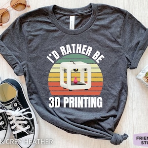 Może przedstawiać: Szary melanżowy t-shirt z nadrukiem w stylu vintage przedstawiającym drukarkę 3D i tekstem "I'd rather be 3D printing".