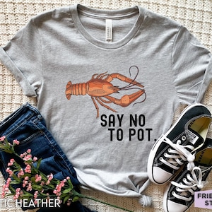 May include: Grey t-shirt with a cartoon crawfish and the text "Say No To Pot."