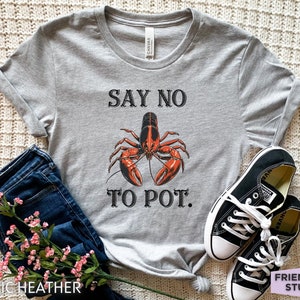 May include: A gray t-shirt with the text "Say No To Pot." and a red lobster illustration.