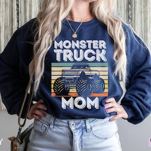 May include: A navy blue sweatshirt with a vintage-style graphic of a monster truck and the text "Monster Truck Mom".