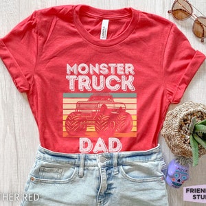 May include: Red t-shirt with a vintage-style graphic of a monster truck and the text "Monster Truck Dad".