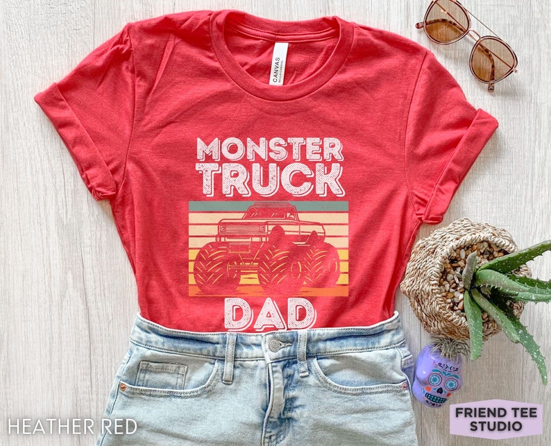 May include: Red t-shirt with a vintage-style graphic of a monster truck and the text "Monster Truck Dad".