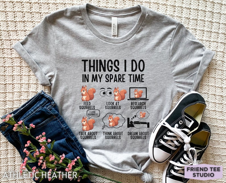 May include: A gray t-shirt with the text "Things I do in my spare time" and a list of activities related to squirrels. The activities include: feed squirrels, look at squirrels, research squirrels, talk about squirrels, think about squirrels, and dream about squirrels.