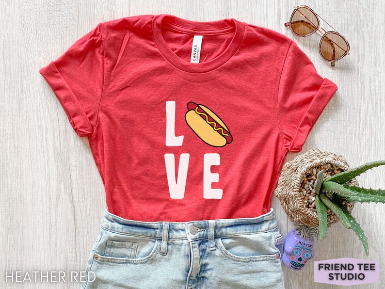May include: A heather red t-shirt with a white graphic of a hot dog and the word "LOVE".