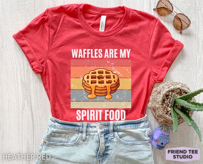Pu&ograve; includere: T-shirt rosso melange con la scritta "WAFFLES ARE MY SPIRIT FOOD" e una grafica di waffle con sciroppo. La maglietta &egrave; realizzata in un materiale morbido ed &egrave; adatta per un abbigliamento casual.