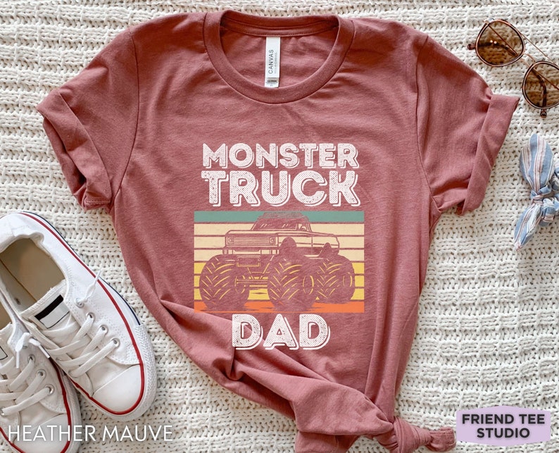 May include: Heather mauve t-shirt with a vintage-style graphic of a monster truck and the text "Monster Truck Dad".