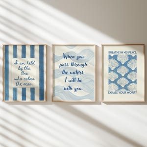 Peut inclure: Trois impressions d'art encadrées avec des citations inspirantes et des thèmes côtiers. Les impressions présentent des motifs bleus et blancs, notamment des rayures, des motifs de vagues et des illustrations de coquillages. Les cadres sont de couleur bois clair.
