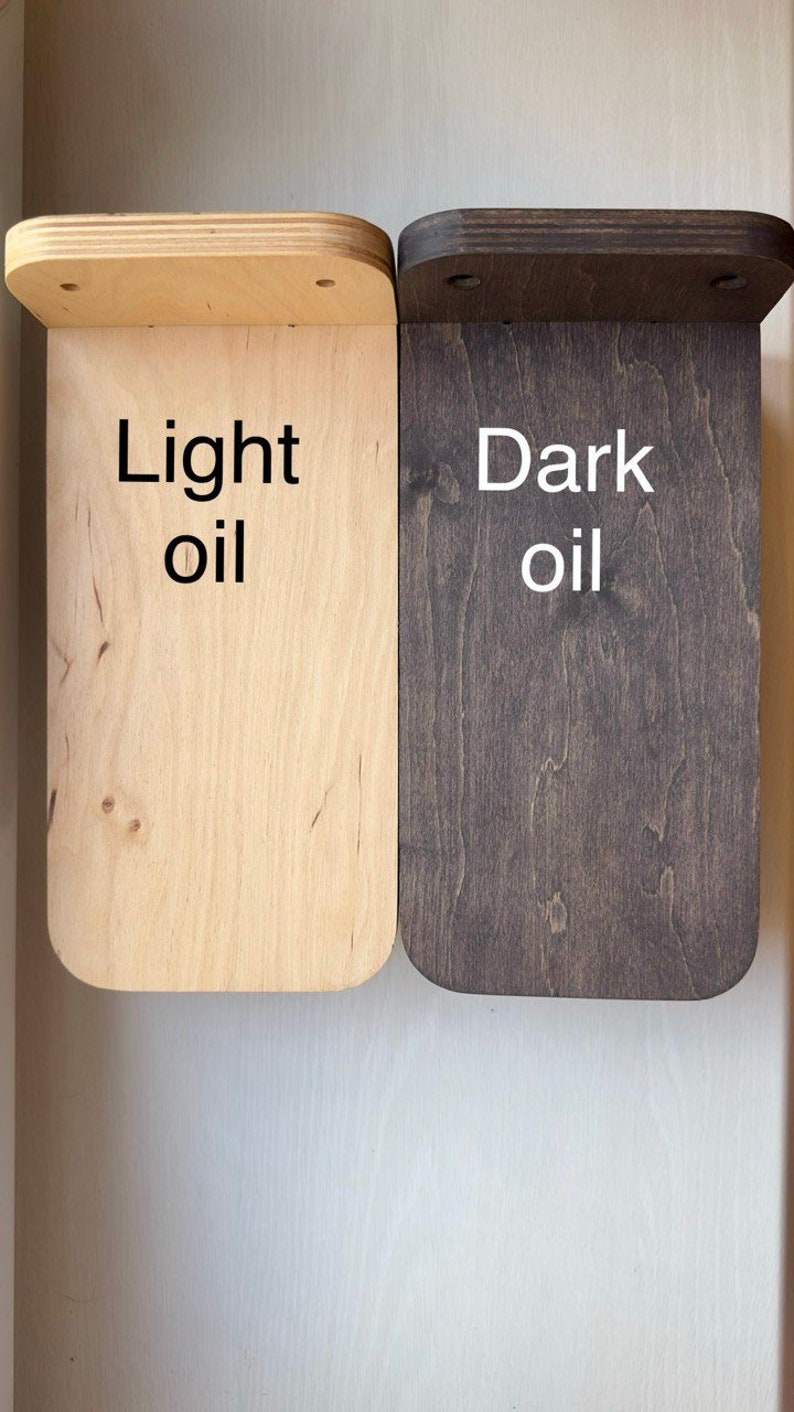 May include: Two wooden shelves, one finished with light oil and the other with dark oil. The shelves are both rectangular and have rounded edges. The text "Light oil" is written on the lighter shelf and "Dark oil" is written on the darker shelf.