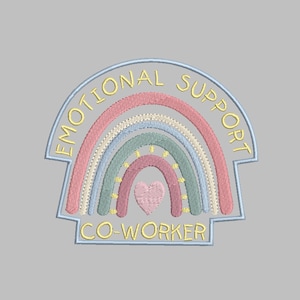 Pode incluir: Um remendo bordado com um design de arco-íris e o texto "Emotional Support Co-Worker". O arco-íris é feito de cores rosa, bege, azul e verde. Um pequeno coração rosa está no centro do arco-íris.