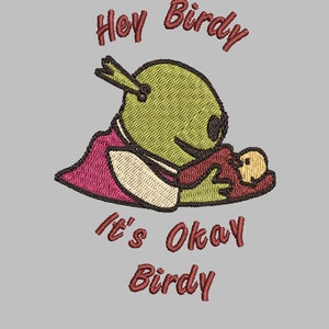 May include: Embroidered design featuring a green alien character with a red cape holding a small yellow bird. The text "Hey Birdy" is above the character and "It's Okay Birdy" is below.