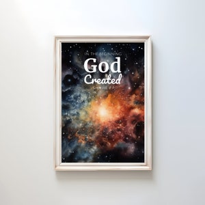 Puede incluir: Una impresión enmarcada con una pintura de acuarela de una nebulosa con estrellas. El texto "En el principio Dios creó" y "Génesis 1:1" está impreso en blanco en la imagen.