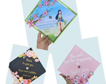 May include: Three graduation caps decorated with flowers and inspirational quotes. The first cap is blue with a pink flower design and a quote from Mulan. The second cap is black with pink flowers and the quote "Plans to give you hope and a future". The third cap is pink with white flowers and the quote "The end, but the beginning of God's plan".