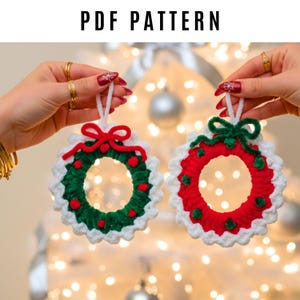 May include: Two crocheted Christmas wreath ornaments. One wreath is red with green and white accents, the other is green with red and white accents. The text "PDF PATTERN" is at the top.