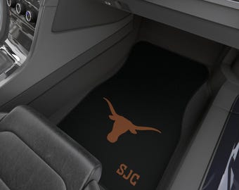 May include: Black car floor mat with a brown Texas Longhorns logo and the initials "SJC" in brown.