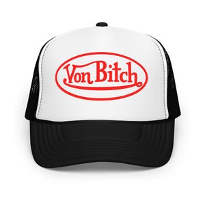 May include: A trucker hat with a white front panel and a black mesh back. The hat features the text "Von Bitch" in red, enclosed in a red oval. The brim is black.