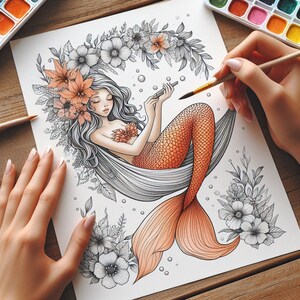 May include: A black and white line drawing of a mermaid with orange and peach colored scales. The mermaid is sitting in a hammock made of flowers and leaves. The mermaid is holding a paintbrush and a palette of watercolors.
