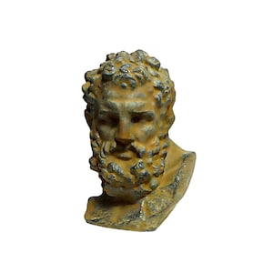 May include: A small, weathered, yellow-brown cast iron bust of a man with a beard. The bust is detailed with a curly hairstyle and a beard with a braided design.