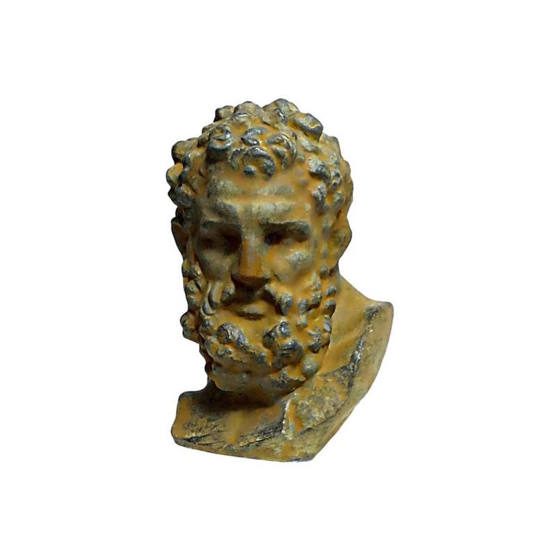 May include: A small, weathered, yellow-brown cast iron bust of a man with a beard. The bust is detailed with a curly hairstyle and a beard with a braided design.