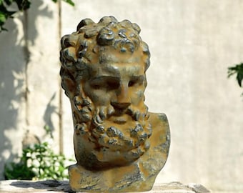 Puede incluir: Un busto de bronce desgastado de un hombre con barba. El busto está detallado con una superficie texturizada y una representación realista de los rasgos del hombre.