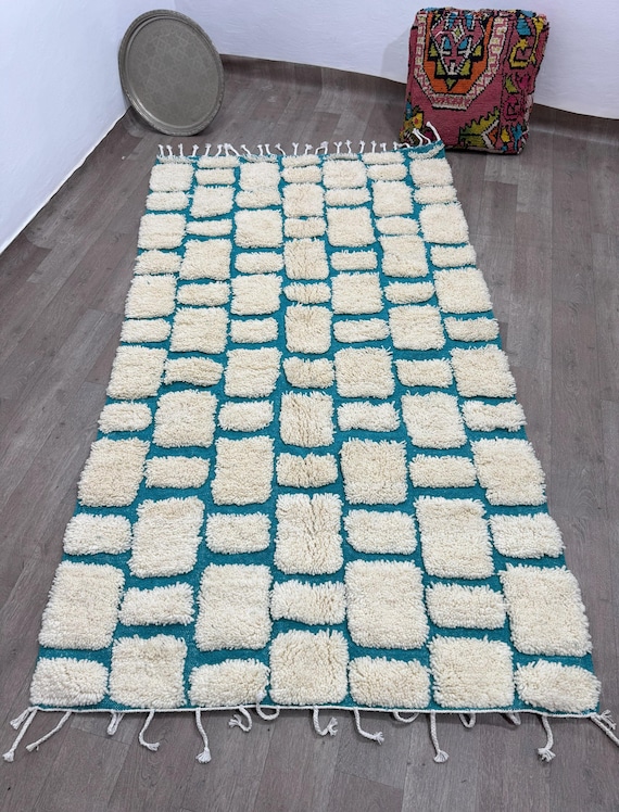 A modern Moroccan rug with a raised square pattern on a blue background, a unique artistic touch in any space.