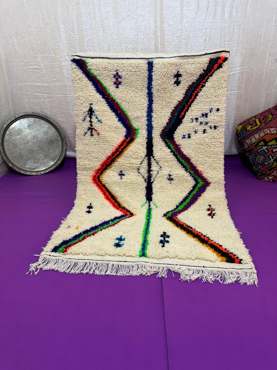 A Moroccan rug with a unique design in blue, orange, and dark green, combining authenticity and modernity in every thread.
