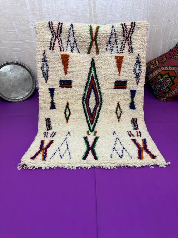 A Moroccan rug with a unique design in blue, orange, and dark green, combining authenticity and modernity in every thread.