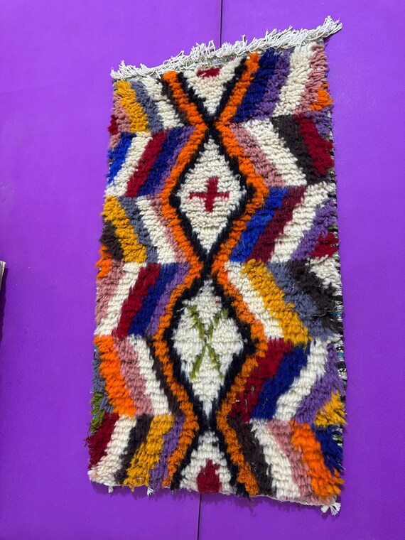 A handmade Berber rabiya with geometric motifs and warm colors inspired by the spirit of the mountain.