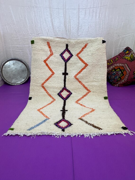 A Moroccan rug with a unique design in blue, orange, and dark green, combining authenticity and modernity in every thread.
