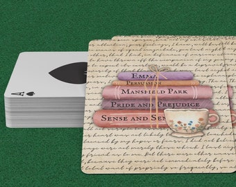 May include: A stack of playing cards with a single card showing the Ace of Spades. The cards are on top of a stack of vintage book covers with the titles "Emma", "Persuasion", "Mansfield Park", "Pride and Prejudice", and "Sense and Sensibility". A small teacup with flowers is on top of the books.