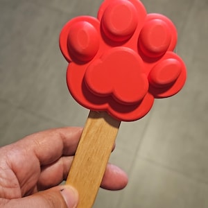 Può includere: Una tazza di ceramica bianca con un design floreale colorato. La tazza ha un manico e un bordo largo. I fiori sono nelle tonalità del rosa, viola e giallo. La tazza è probabilmente per caffè o tè.