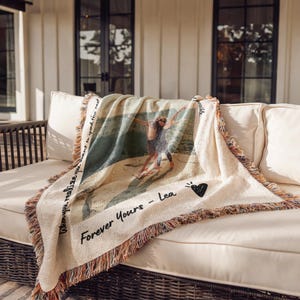 May include: A woven throw blanket with a photo of two people on a beach. The blanket has a fringe border and the text "When you realize you want to spend the rest" and "Forever Yours - Lea" printed on it.