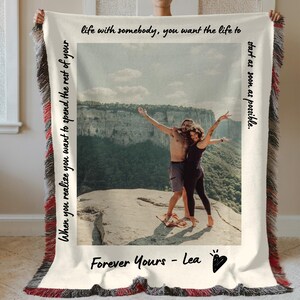 May include: A white throw blanket with a photo of a couple standing on a mountaintop. The text "When you realize you want to spend the rest of your life with somebody, you want the life to start as soon as possible." is printed on the left side of the blanket. The text "Forever Yours - Lea" is printed below the photo.
