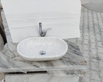 May include: White marble bathroom sink with a chrome faucet and a white marble countertop.