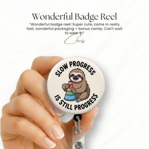 K&ouml;nnte beinhalten: Ein wei&szlig;es Badge-Reel mit dem Text "SLOW PROGRESS IS STILL PROGRESS", der ein Cartoon-Faultier mit bunten Stapelbechern umgibt. Das Badge-Reel hat auch den Text "Wonderful Badge Reel" und eine Kundenbewertung.