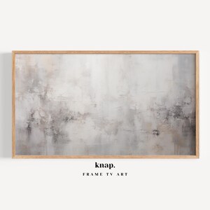 May include: A framed abstract painting with a light gray background and subtle shades of brown and black. The painting has a textured look, resembling a concrete wall. The frame is a light wood color.