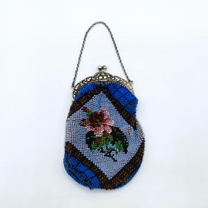 May include: A vintage beaded purse with a silver chain and clasp. The purse is blue, brown, and white with a floral design.