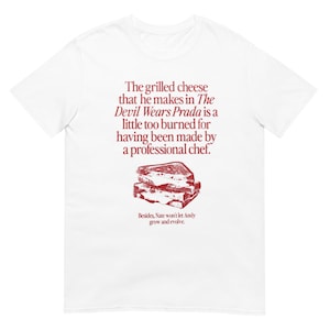 Puede incluir: Camiseta blanca con texto rojo que dice "The grilled cheese that he makes in The Devil Wears Prada is a little too burned for having been made by a professional chef. Besides, Nate won't let Andy grow and evolve."  Una ilustración roja de un sándwich de queso a la parrilla está debajo del texto.