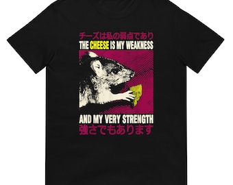 May include: Black t-shirt featuring a graphic of a rat holding a piece of cheese, with text in English and Japanese. The text reads "THE CHEESE IS MY WEAKNESS" and "AND MY VERY STRENGTH". The design is set against a pink and red background.