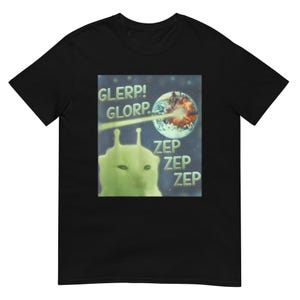 May include: Black t-shirt with a retro graphic. The design shows a green alien with the words "GLERP! GLORP." and "ZEP ZEP ZEP." A planet is being attacked by a laser beam. The shirt is made of a soft material.