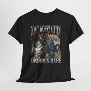 May include: Black t-shirt with the text "DON'T WORRY KITTEN DADDY'S HERE" in a silver font. The graphic depicts werewolves, a full moon, and flames. A dark, gothic-themed design.
