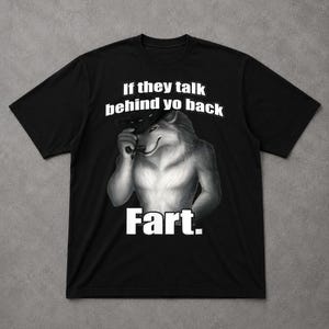 May include: Black t-shirt with a wolf illustration and the text "If they talk behind yo back Fart." The wolf is rendered in grey and white, wearing a hat and smirking. The text is in a bold, white font.