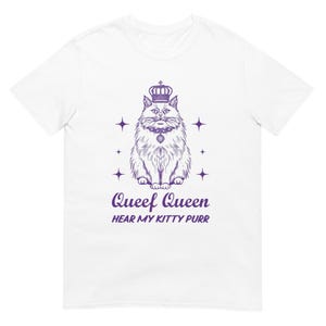 May include: White t-shirt featuring a purple illustration of a regal cat wearing a crown and a necklace. The text "Queef Queen" and "Hear My Kitty Purr" are below the cat. Four star shapes surround the cat.