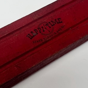 Könnte beinhalten: Eine rote Holzkiste mit dem Aufdruck "HAPPY TIME SEARS ROEBUCK AND CO" auf der Oberseite.