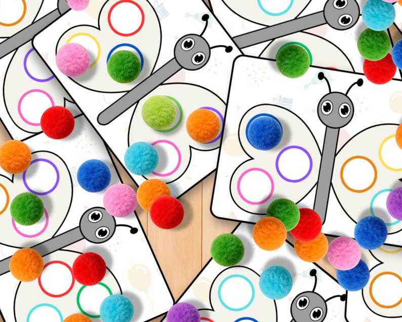 May include: Butterfly-shaped cards with colorful circles and matching pom-poms in various colors, including red, orange, green, blue, and pink. The cards have a gray butterfly design with a white background. Educational toy.